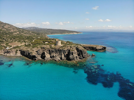 Vista dall'alto di una spiaggia in Sardegna con acque turchesi e cristalline