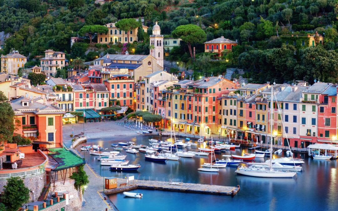 Abend in Rapallo: beleuchtete Promenade und Hafen mit reflektierendem Wasser.