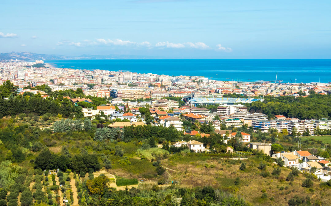 Blick auf den Strand von Pescara mit klarstem Wasser und der Küste im Hintergrund, ein idealer Ort für Entspannung und Wassersport.