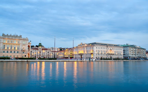 Panorama der Piazza Unità d'Italia in Triest, umgeben von historischen Gebäuden, mit Blick auf die Adria und reich an Geschichte und Kultur.