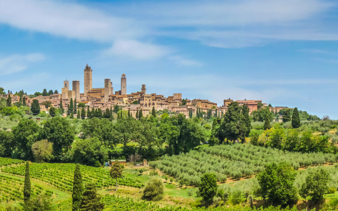 Blick auf San Gimignano mit seinen berühmten mittelalterlichen Türmen und der toskanischen Landschaft im Hintergrund.