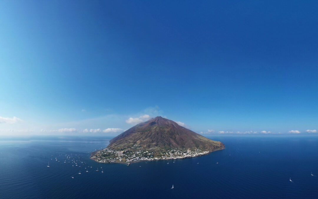 Vulkan Stromboli: Ausbruch des aktiven Vulkans mit Lavafontänen, die den Nachthimmel erleuchten, gesehen von der Insel Stromboli.